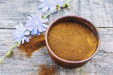 Mavi hindiba çiçeği ve eski bir ahşap masada anlık hindiba tozu bir kase. Hindiba tozu. Sağlıklı bir içecek yeme kavramı.