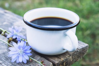 Ahşap bir masa üzerinde hindiba içecek ve mavi hindiba çiçekleri ile Fincan. Hindiba tozu. Sağlıklı beslenme konsepti.