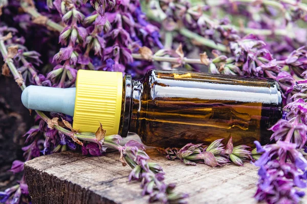 Lavender essential oil in a glass bottle and lavender colors on a rustic wooden background. Tincture or essential oil with lavender. herbal medicine.