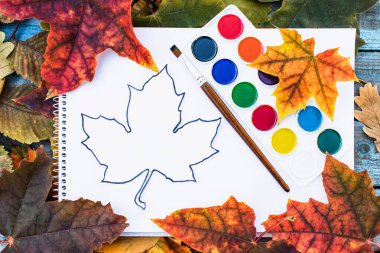 Renkli sonbahar yaprakları ve yazı için yeri olan beyaz kağıtların yanında resim yapmak için. Sonbahar yapraklı arka plan. Yazı için alanı kopyala.