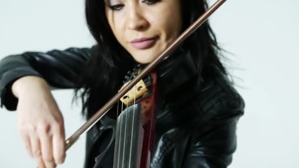 タイトな黒い革の服を着たスレンダーな官能的な芸術的なアジアの少女は 表現力豊かに電気バイオリンを果たしています — ストック動画