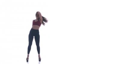 Genç ve güzel bir kız beyaz arka planda modern dans ediyor, plastikleri soyuyor.