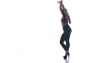 Genç ve güzel bir kız beyaz arka planda modern dans ediyor, plastikleri soyuyor.