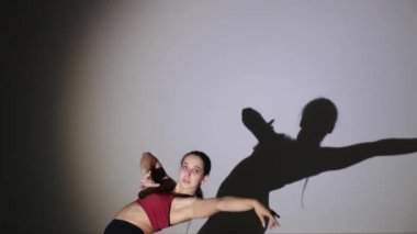 Dans eden genç güzel kız, gölge hareketlerini tekrarlıyor.