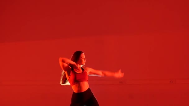 若い美しい女性が赤い背景でVogueを踊る — ストック動画