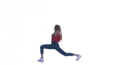 Genç, güzel bir kadın hip-hop yapıyor, beyaz arka planda sokak dansı yapıyor, izole edilmiş.