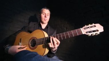 siyah tuğla duvar arka planda flamenko müzik çalan gitarist
