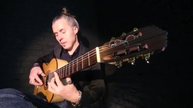 siyah tuğla duvar arka planda flamenko müzik çalan gitarist