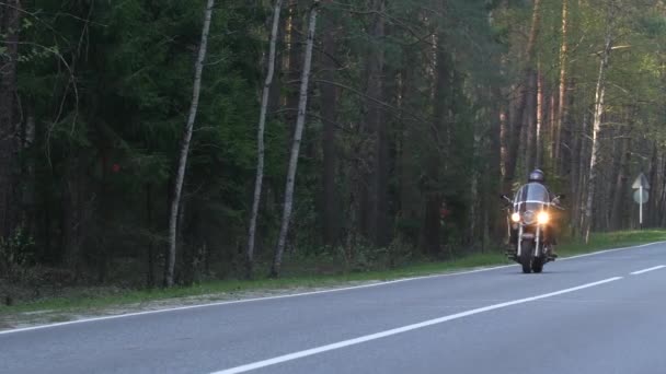 Hombre Motorista Casco Monta Una Motocicleta Largo Camino Forestal Atardecer — Vídeos de Stock