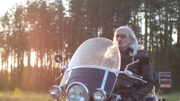 Homem Adulto Com Cabelos Grisalhos Longos Senta Uma Motocicleta Pôr — Vídeo de Stock