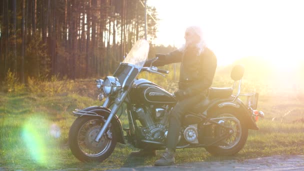 Dorosły Człowiek Długimi Szarymi Włosami Siedzi Motocyklu Zachodzie Słońca — Wideo stockowe