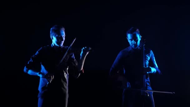 Duet Młodych Muzyków Grających Wiolonczelę Elektryczną Skrzypce Elektryczne Czarnym Tle — Wideo stockowe