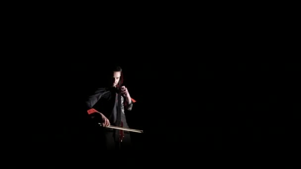 年轻英俊的男子在黑色背景上弹奏大提琴 与世隔绝 — 图库视频影像