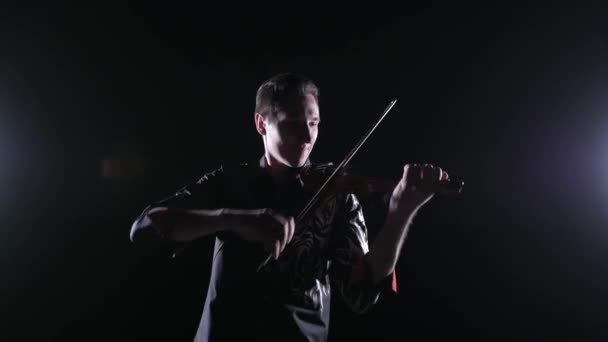 年轻英俊的男子在黑色背景上弹奏小提琴 与世隔绝 — 图库视频影像