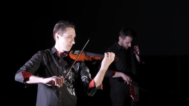 Dúo Jóvenes Tocando Violonchelo Eléctrico Violín Eléctrico Sobre Fondo Negro — Vídeo de stock