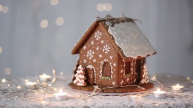 Kar taneleri ile dekore pırıl pırıl ışıkların arka planda el yapımı zencefilli ev,