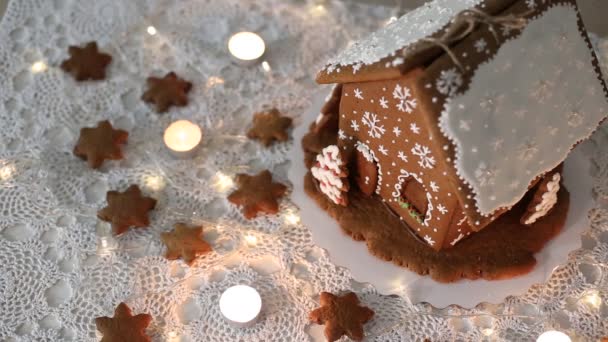 Handgjorda Pepparkakshus Bakgrund Glittrande Ljus Dekorerad Med Snöflingor — Stockvideo