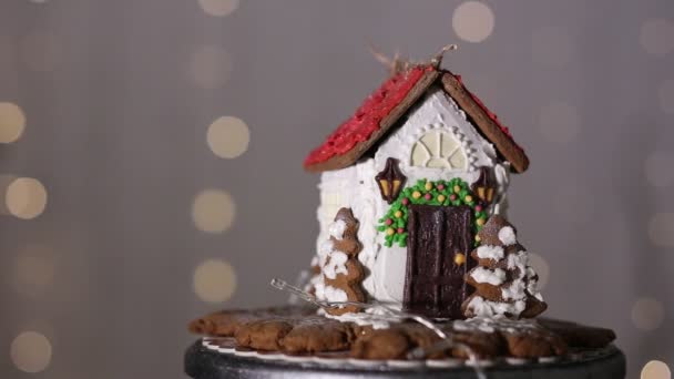 Handgemaakte Peperkoek Huis Achtergrond Van Sprankelende Lichten Wit Chocolade Glazuur — Stockvideo