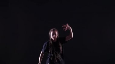 Afrika örgülü güzel bir kız hip hop yapıyor, stüdyoda siyah bir arka planda sokak dansı yapıyor, izole edilmiş.
