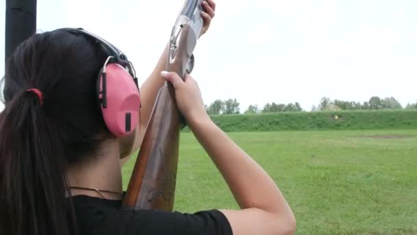 年轻漂亮的姑娘在一个开放的射击场射中了一个飞行的目标 陷阱射击 — 图库视频影像