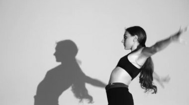 genç kız dans modern bale, çağdaş dans, izole, gölge onun hareketlerini tekrarlar, yavaş hareket