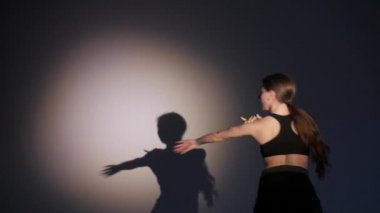 genç kız dans modern bale, çağdaş dans, izole, gölge onun hareketlerini tekrarlar, yavaş hareket