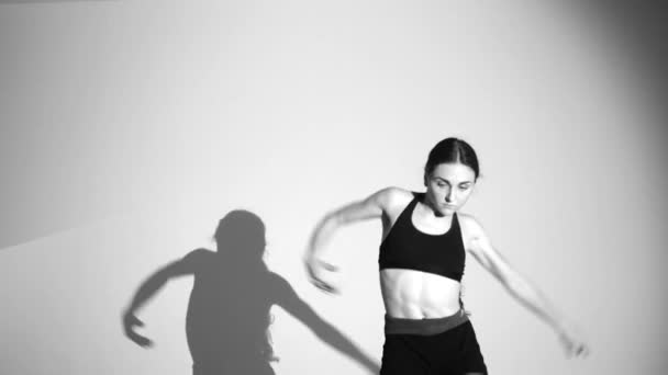 年轻女孩跳现代芭蕾 当代舞蹈 阴影重复她的动作 慢动作 — 图库视频影像