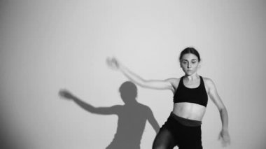 genç balerin dans çağdaş dans, izole, gölge onun hareketlerini tekrarlar, yavaş hareket