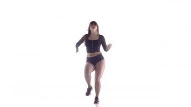 Uzun saçlı, uzun saçlı, genç, şehvetli bir dansçı kız. Tayt ve şortla dans ediyor. Dans pisti twerk dansı, modern dans, kalçalarını sallıyor.