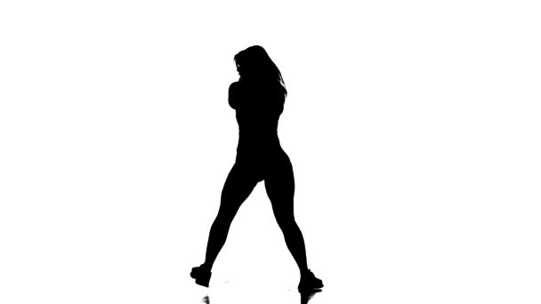白を基調とした黒のシルエット 若い美しい女性ダンサー フィッシュネットタイツとショートパンツダンスホールトルコ ストリートモダンダンス ロングショット — ストック動画