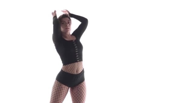 Plan moyen long de jeune danseuse sensuelle aux cheveux longs en collants et shorts résille dansant vigoureusement dancehall twerk, street modern dance, secouant ses fesses, isolée, au ralenti 