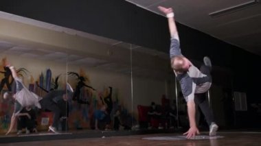 Genç dansçı aynalarla koridorda kırılıyor. Dans okulu. Gençlik alt kültürü. Çağdaş koreografi. Yavaş çekim 