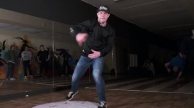 Spor salonunda ağır çekimde yel değirmeni yapıp dans eden genç bir adam. Break dans tekniğini geliştirme kavramı. Gençlik alt kültürü. Çağdaş koreografi
