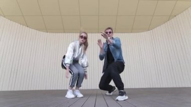 Genç adam ve kız şehir parkında modern sokak dansı yapıyorlar. Gençlik alt kültürü. Düşük çekim noktası