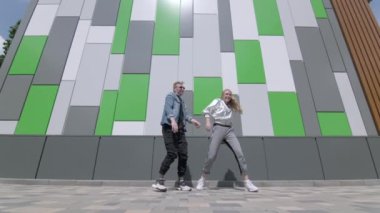 Çağdaş koreografi dansı yapan genç dansçıların düeti, halka açık bir parkta sokak arası dansı. Gençlik alt kültürü. Düşük çekim noktası