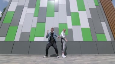 Çağdaş koreografi dansı yapan genç dansçıların düeti, halka açık bir parkta sokak arası dansı. Gençlik alt kültürü. Düşük çekim noktası