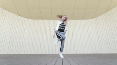 Güzel kız halk parkında dans edip modern koreografi sokak dansı yapıyor. Gençlik alt kültürü. Düşük atış noktası. Yavaş çekim