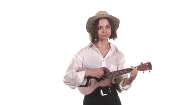中长镜头年轻的音乐家女人穿着白衬衫 头戴帽子 弹奏着四弦琴 孤立无援包扎 — 图库视频影像