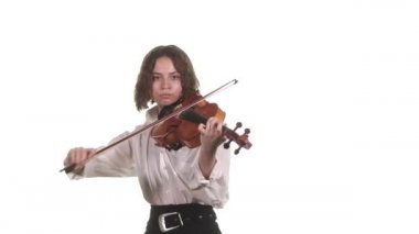 Beyaz bluzlu güzel bir kemancı kızın sahne ışıklarının önünde klasik keman çalmasını yakından çek. İzole edilmiş