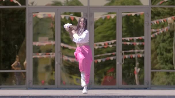 建物の前でクールなダンスをする才能のある女の子 ヒップホップやブレイクダンスのテクニックを学ぶというコンセプト 若いサブカルチャーだ コンテンポラリー振付 スローモーション — ストック動画