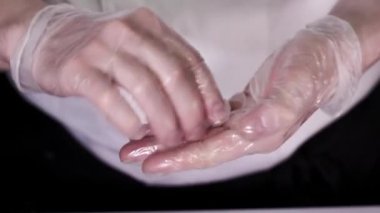 Eldiven giymiş şefin önden görünüşü Japon suşi rulolarını pilav ve somon yapar. Japon yemeği. Yavaş çekim