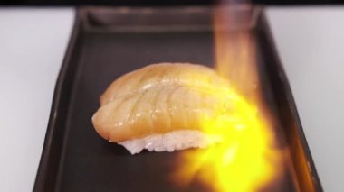 Suşi hazırlama süreci, müşterilere servis yapılmadan önce tüten balık ateşi. Suşi pişirme dersi. Restoran mutfağı. Japon yemeği. Yavaş çekim