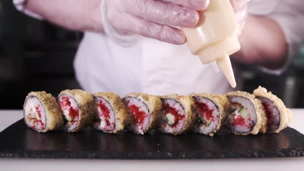 一位年轻的寿司厨师用米饭 红鱼子酱和诺莉做日本寿司卷 餐厅厨房 手部特写日本菜 — 图库视频影像
