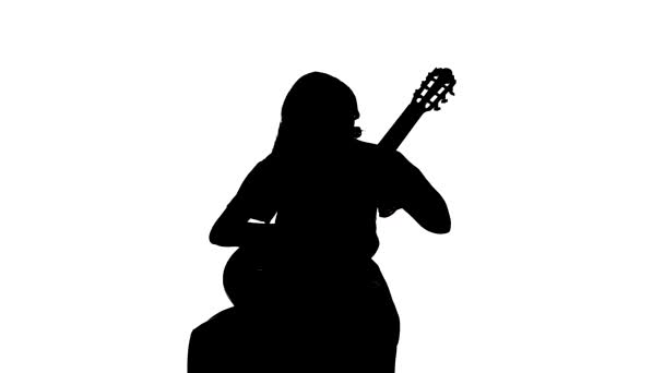 fekete sziluett fehér háttérrel, csinos lány játszik a klasszikus akusztikus gitáron. Közepes távolságtartó