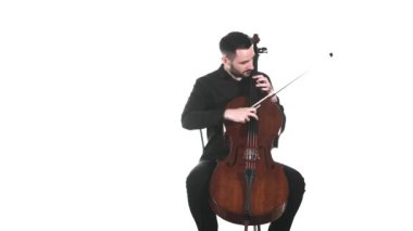 Siyah gömlekli yetenekli bir çellocu klasik bir çello çalar. Pizzicato tekniği. İzole edilmiş. Orta uzunlukta.