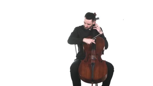 身穿黑色衬衫的出色音乐家在古典大提琴上演奏着优美而缓慢的旋律 孤立无援中长枪 — 图库视频影像