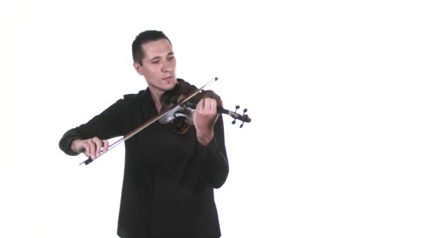 黒のシャツに身を包んだハンサムな男性ヴァイオリニストがクラシックバイオリンでゆっくりと旋律を奏でます 隔離されてる 中ロングショット — ストック動画
