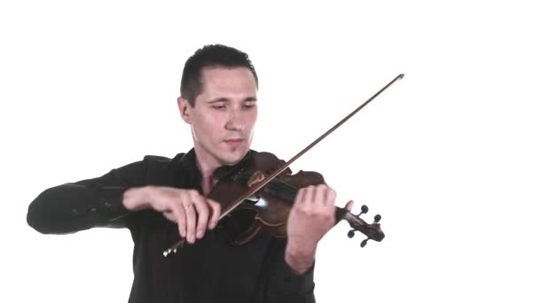 黒のシャツに身を包んだハンサムな男性ヴァイオリニストがクラシックバイオリンでゆっくりと旋律を奏でます 隔離されてる 中ロングショット — ストック動画