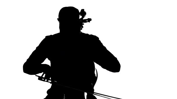 クラシックチェロを上手に演奏する若きチェロ奏者 白い背景に黒いシルエット 中ロングショット — ストック動画