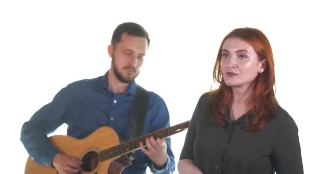 Chitarist Chipeș Barbă Însoțește Fată Părul Roșu Chitară Fundal Alb — Videoclip de stoc